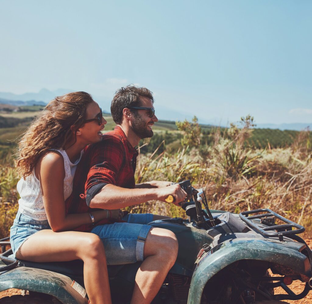 Couple driving off-road with quad bike